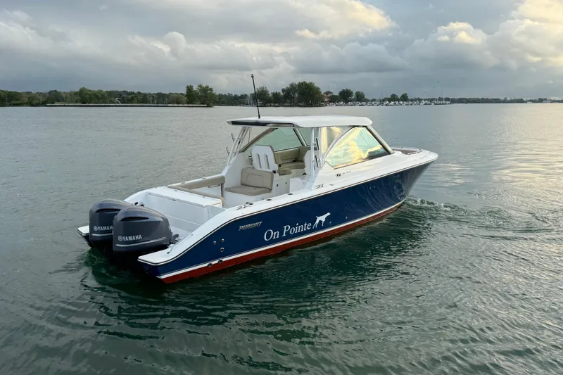 Slide: The Image of 2016 Pursuit DC 325 Dual Console boat on calm water with Yamaha engines. - 5