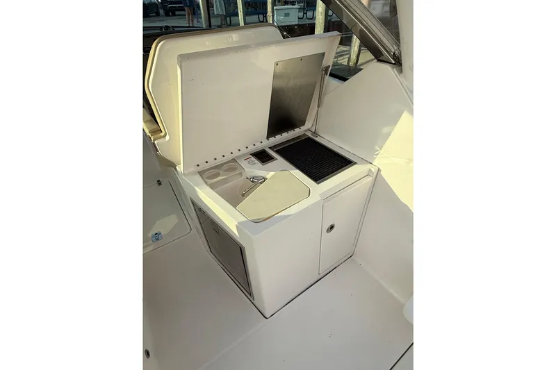 Slide: The Image of 2016 Pursuit DC 325 Dual Console boat interior with open grill and storage. - 50