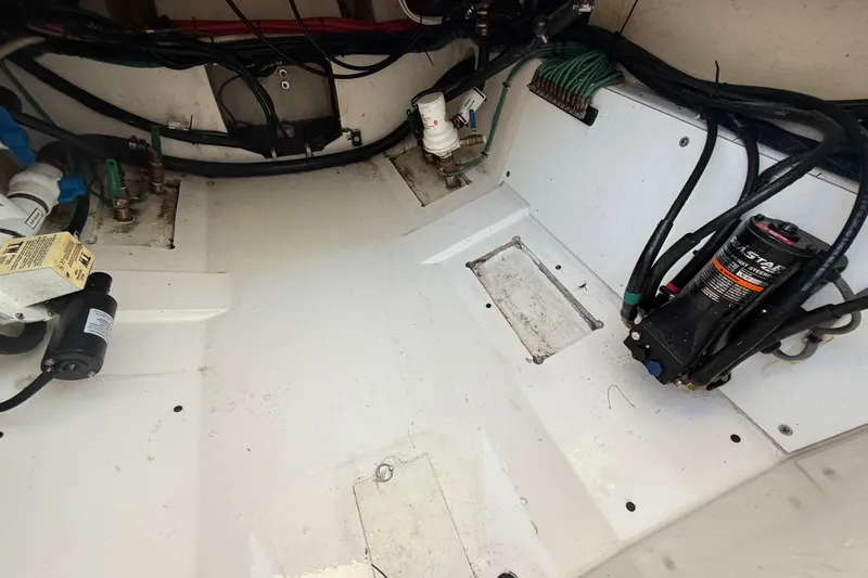 Slide: The Image of 2016 Pursuit DC 325 Dual Console boat interior showing wiring and mechanical components. - 54