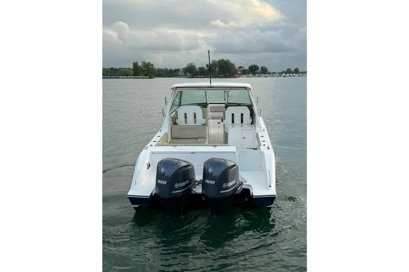 Slide: The Image of 2016 Pursuit DC 325 Dual Console boat with twin Yamaha 300 engines on a calm lake. - 8