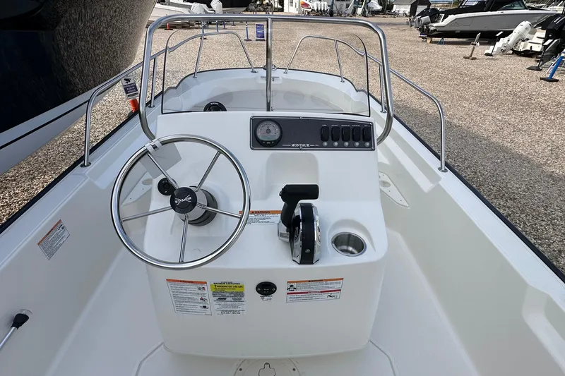 Slide: The Image of 2026 Boston Whaler 170 Montauk boat console with steering wheel and controls. - 12
