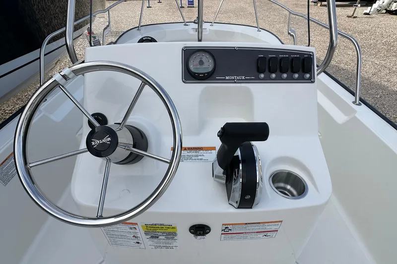 Slide: The Image of 2026 Boston Whaler 170 Montauk boat console with steering wheel and controls. - 13