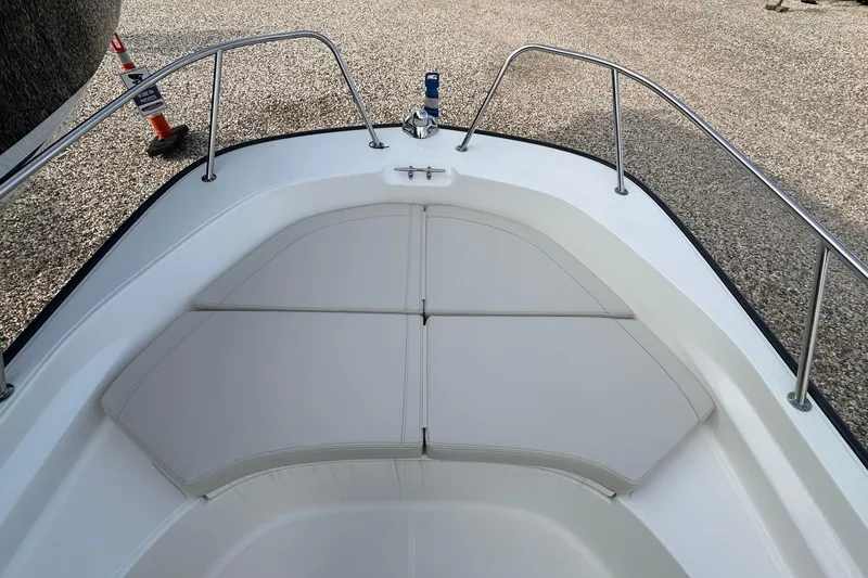 Slide: The Image of 2026 Boston Whaler 170 Montauk boat bow with cushioned seating and stainless steel railings. - 19