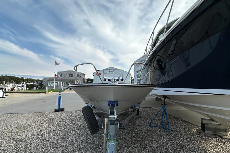 Slide: The Image of 2026 Boston Whaler 170 Montauk on trailer at marina, clear sky background. - 20