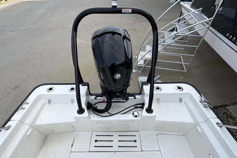 Slide: The Image of 2026 Boston Whaler 170 Montauk boat with outboard motor and railing, docked near metal stairs. - 7