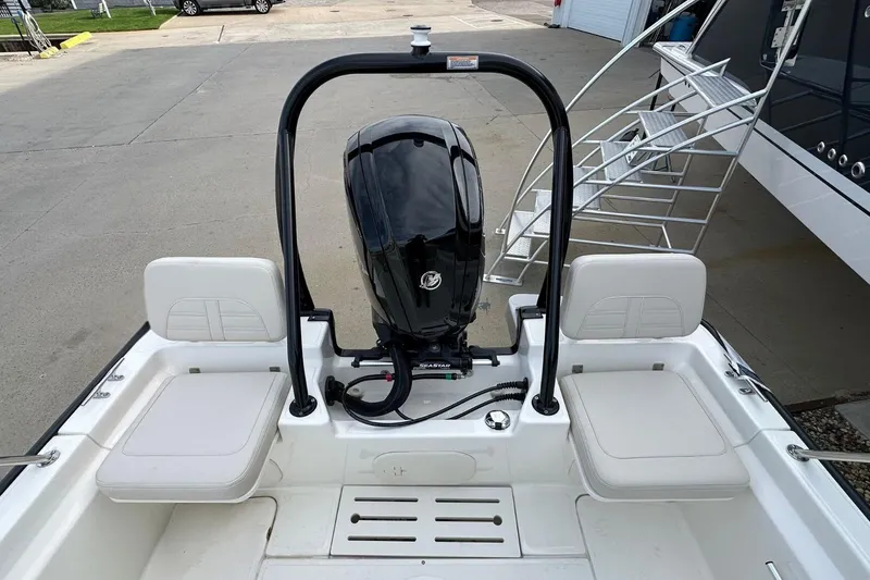Slide: The Image of 2026 Boston Whaler 170 Montauk boat interior with motor and seating, docked near a staircase. - 8
