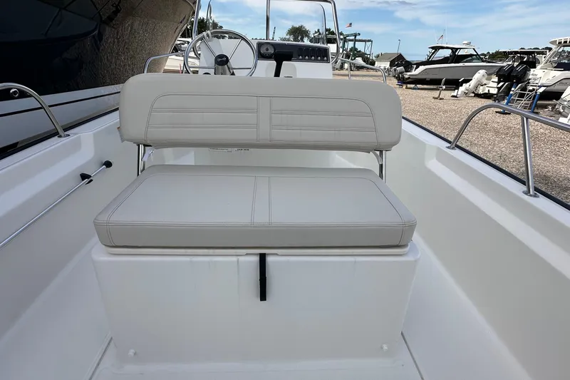 Slide: The Image of 2026 Boston Whaler 170 Montauk boat interior with cushioned seating and steering console. - 9