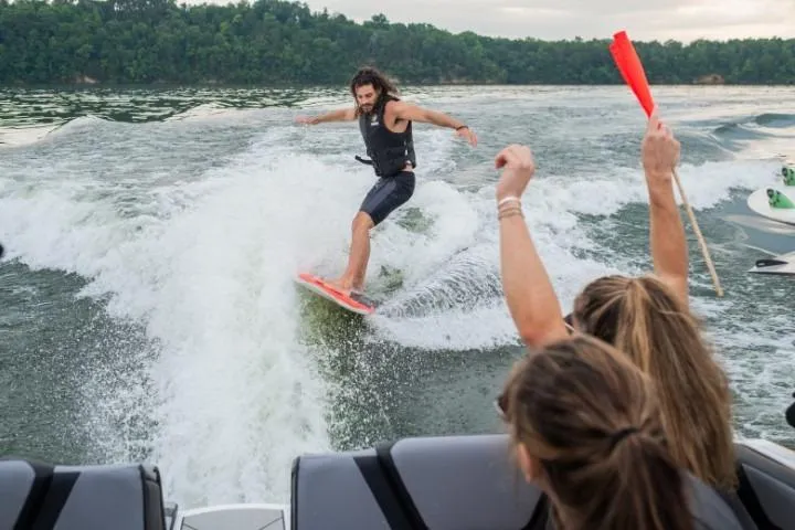 Slide: The Image of Man wakesurfing behind 2026 Yamaha Boats 222XD, with cheering friends onboard. - 4