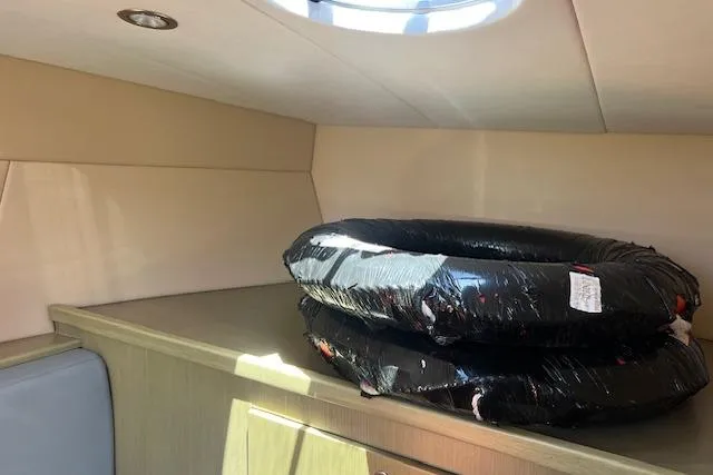 Slide: The Image of Interior of 2024 Bracewell 25 boat with stacked black tires on wooden surface. - 13