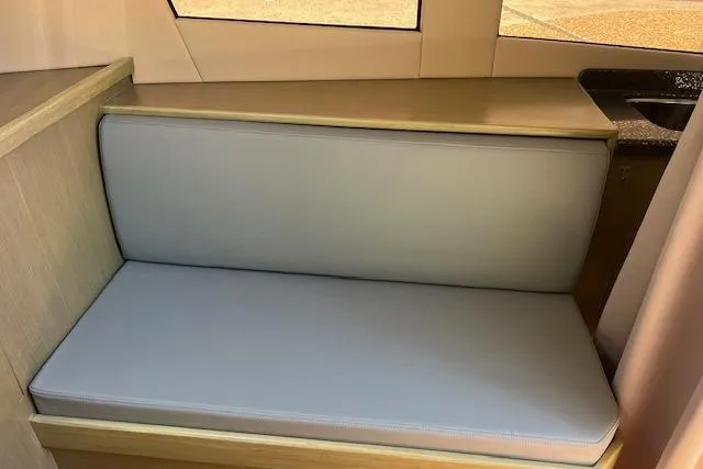 Slide: The Image of 2024 Bracewell 25 interior seating with light gray cushion and wooden accents. - 14