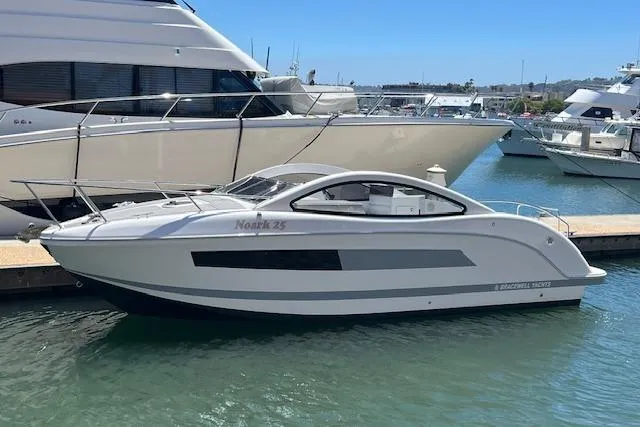 Slide: The Image of Modern 2024 Bracewell 25 boat docked in marina, sleek design and white exterior. - 3