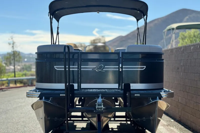 Slide: The Image of 2023 Apex Qwest 822 pontoon boat with canopy, parked on a sunny day. - 2