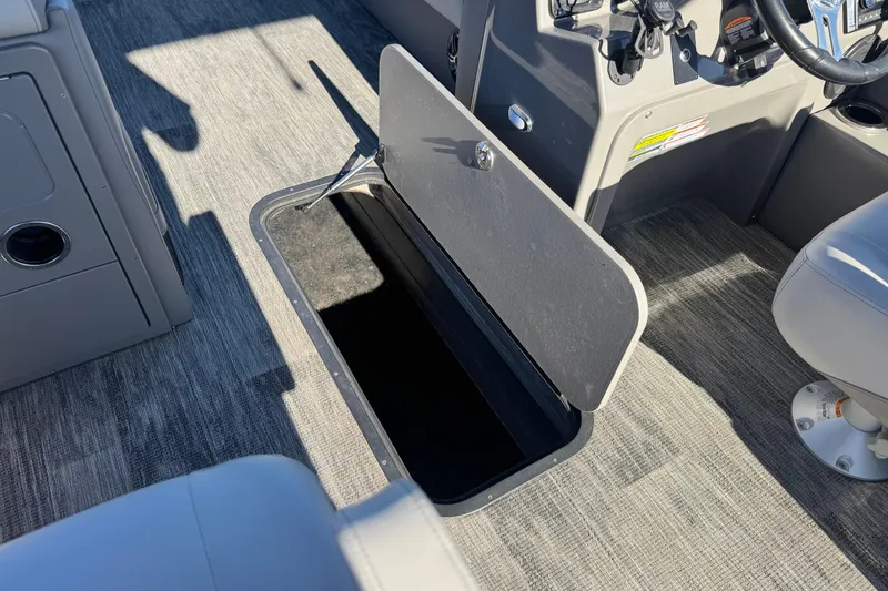 Slide: The Image of Open storage compartment on 2023 Apex Qwest 822 boat, featuring gray interior and seating. - 20