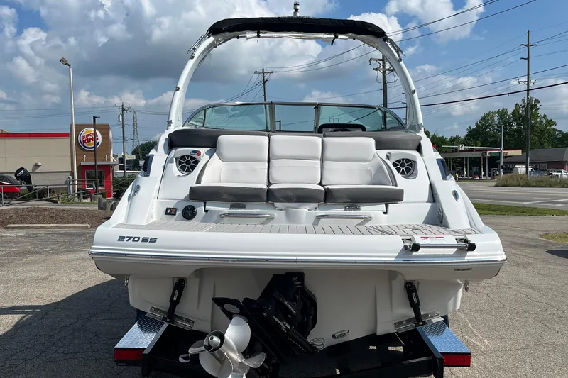 Slide: The Image of 2026 Crownline 270 SS boat, rear view, parked outdoors near a Burger King. - 2