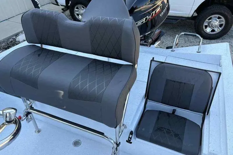 Slide: The Image of 2026 Xpress H20B boat interior with gray cushioned seats and storage compartment. - 10