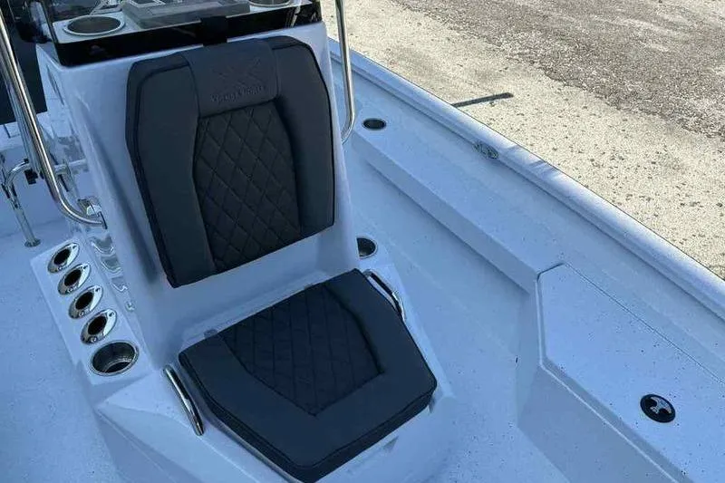 Slide: The Image of 2026 Xpress H20B boat interior with black cushioned seating and rod holders. - 14