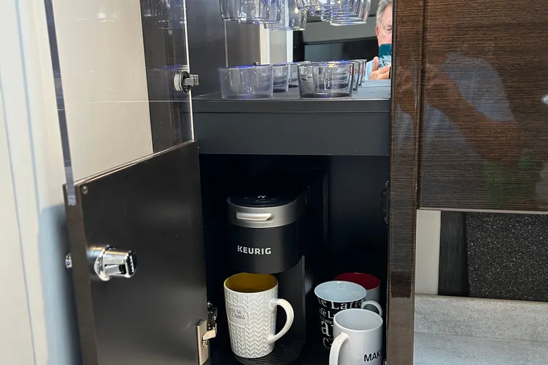 Slide: The Image of Keurig coffee maker and mugs inside a cabinet on a 2016 Formula 40 Cruiser. - 43