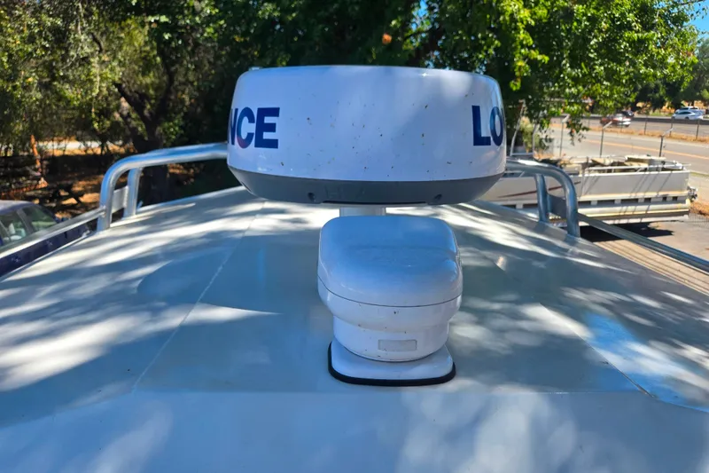 Slide: The Image of Rooftop radar equipment on a 2021 Raider 210.Explorer boat under trees. - 12