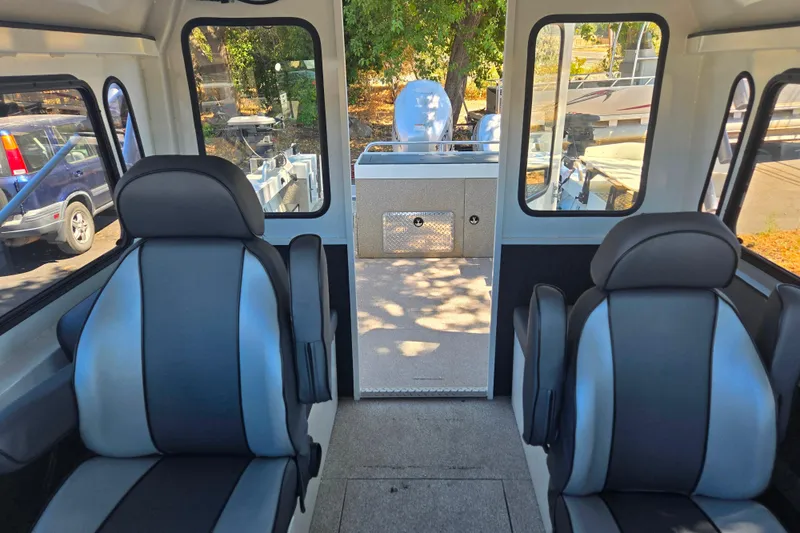 Slide: The Image of Interior of 2021 Raider 210.Explorer boat with two black and gray seats. - 16