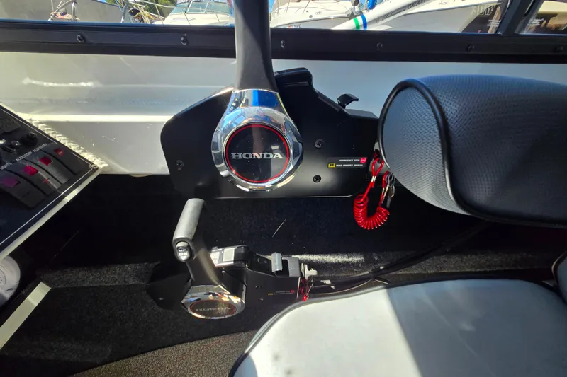 Slide: The Image of Interior of a 2021 Raider 210.Explorer boat with Honda controls and red safety cord. - 20