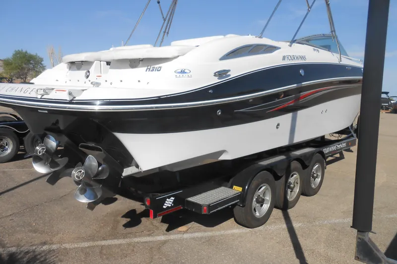 Slide: The Image of 2008 Four Winns H Series H310 boat on trailer, showcasing dual propellers. - 4