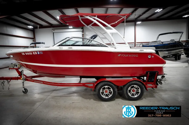 Slide: The Image of Red 2020 Four Winns H210 boat on trailer in indoor showroom. - 10