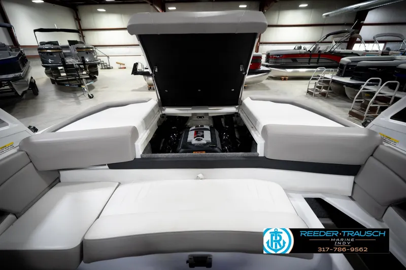 Slide: The Image of 2020 Four Winns H210 boat engine compartment in showroom, featuring spacious seating. - 22