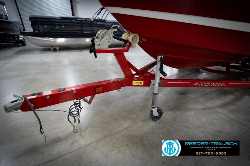 Slide: The Image of 2020 Four Winns H210 boat trailer in a showroom, featuring a red frame. - 51