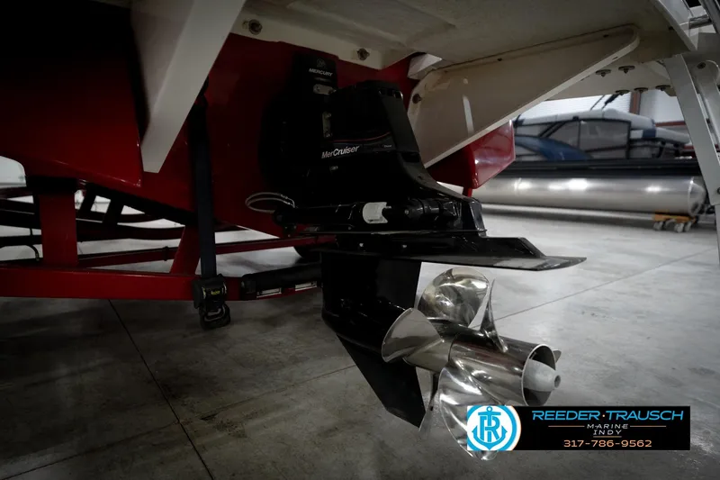 Slide: The Image of 2020 Four Winns H210 boat with MerCruiser engine and propeller, displayed indoors. - 57