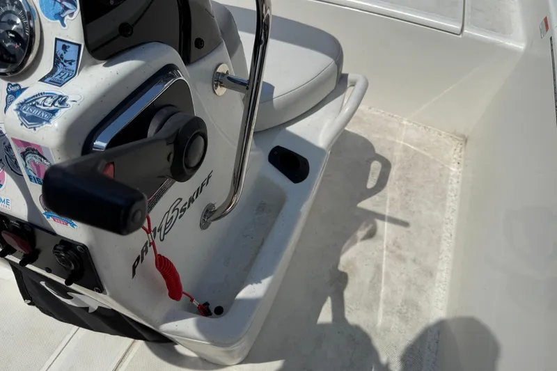 Slide: The Image of 2022 Mako Pro Skiff 15 CC boat console with control lever and fishing stickers. - 12