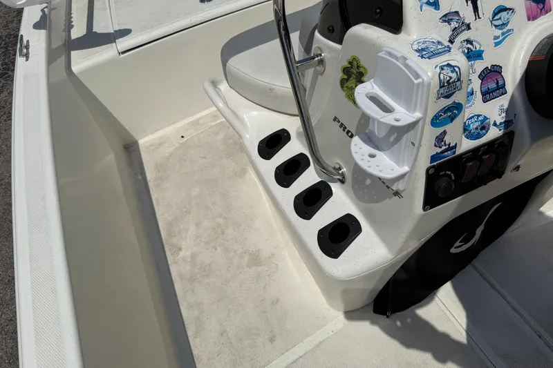 Slide: The Image of 2022 Mako Pro Skiff 15 CC boat console with stickers and rod holders. - 13