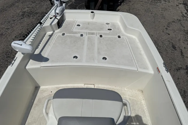 Slide: The Image of 2022 Mako Pro Skiff 15 CC boat interior with seating and storage compartments. - 14