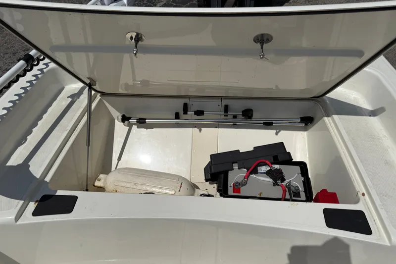 Slide: The Image of Open storage compartment of 2022 Mako Pro Skiff 15 CC with battery and equipment. - 17