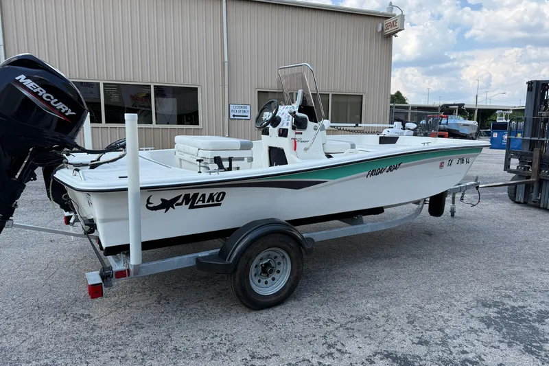 Slide: The Image of 2022 Mako Pro Skiff 15 CC boat on trailer, parked outside a service building. - 5