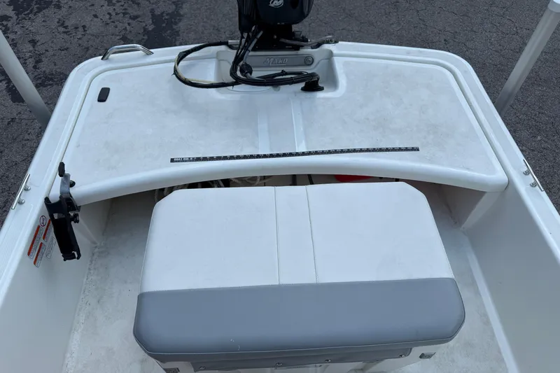 Slide: The Image of 2022 Mako Pro Skiff 15 CC boat interior with seating and motor controls. - 7