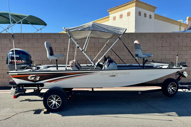 Slide: The Image of 2023 G3 SPORTSMAN 170 boat with Yamaha engine, parked on a trailer, featuring a canopy. - 0