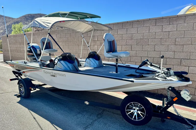 Slide: The Image of 2023 G3 SPORTSMAN 170 boat with canopy and trailer, parked outdoors. - 1