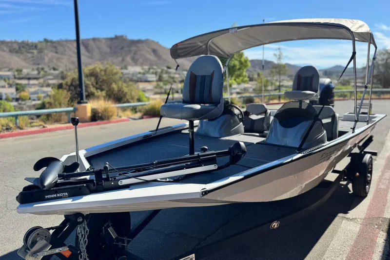 Slide: The Image of 2023 G3 SPORTSMAN 170 boat with canopy and fishing seats, parked outdoors. - 3