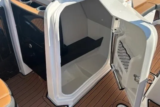 Slide: The Image of 2026 Yamaha Boats 252SD interior storage compartment with open door, showcasing sleek design and functionality. - 15