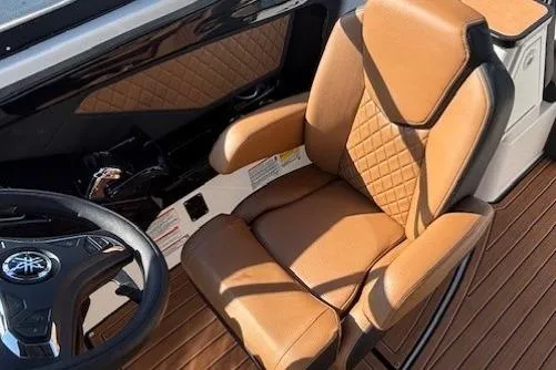 Slide: The Image of 2026 Yamaha Boats 252SD captain's seat with tan upholstery and sleek steering wheel design. - 19