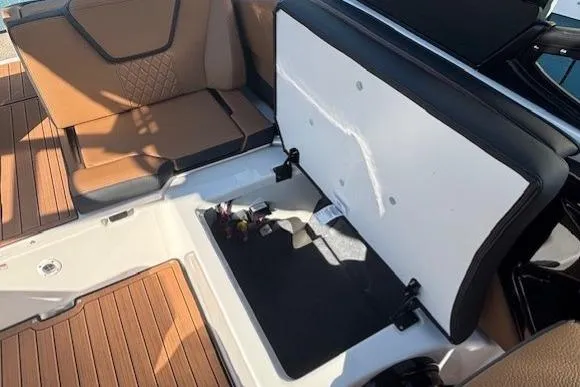 Slide: The Image of 2026 Yamaha Boats 252SD interior storage compartment with brown seating and wood-like flooring. - 26