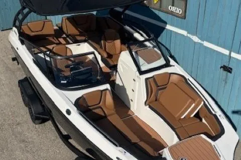 Slide: The Image of 2026 Yamaha Boats 252SD with brown seating, docked near a blue wall. - 7