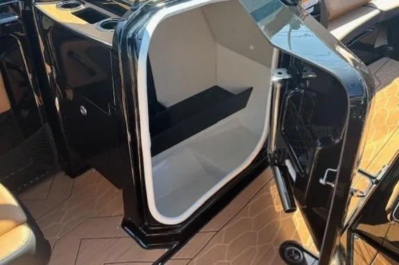 Slide: The Image of Open storage compartment on 2026 Yamaha Boats 255XD, featuring sleek black interior design. - 17
