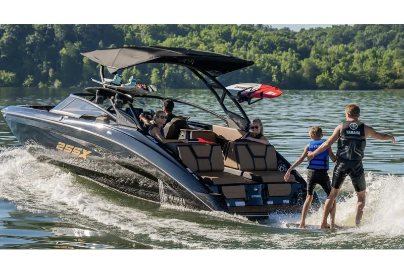 Slide: The Image of 2026 Yamaha Boats 255XD, sleek black design, on trailer, outdoor setting. - 2