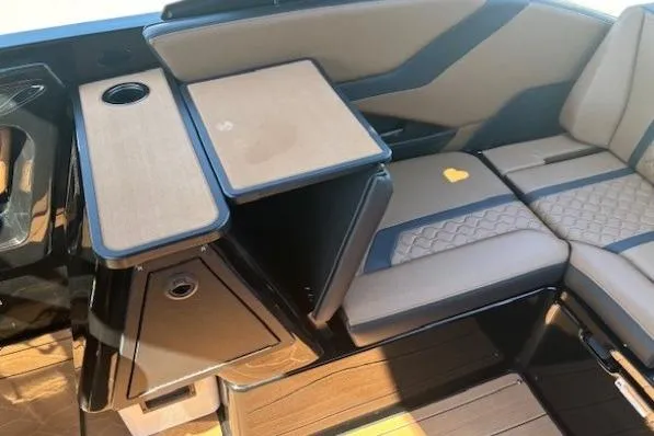 Slide: The Image of 2026 Yamaha Boats 255XD interior with seating and table, featuring modern design and cup holder. - 24