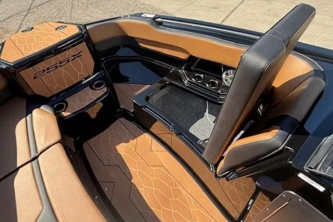 Slide: The Image of 2026 Yamaha Boats 255XD interior with tan and black seating, cup holders, and storage. - 8