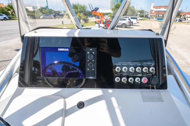 Slide: The Image of 2016 Sportsman Masters 207 Bay Boat dashboard with Simrad display and control switches. - 16