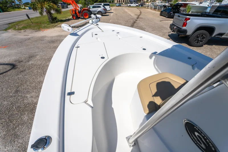 Slide: The Image of 2016 Sportsman Masters 207 Bay Boat, white deck, parked near vehicles and trees. - 18