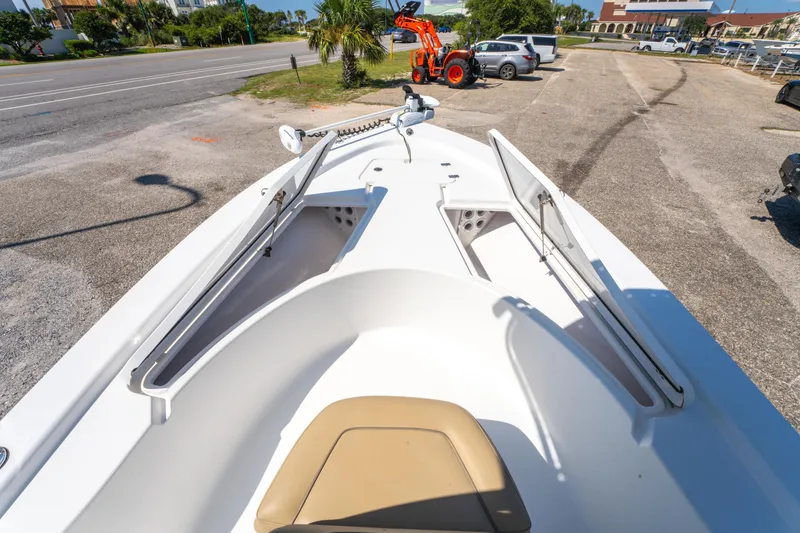 Slide: The Image of 2016 Sportsman Masters 207 Bay Boat with open storage compartments, parked near a road. - 22