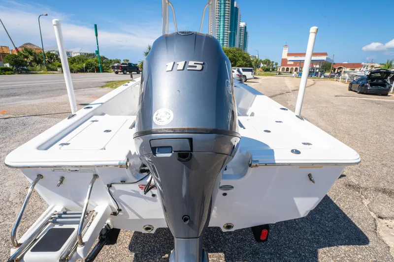 Slide: The Image of 2016 Sportsman Masters 207 Bay Boat with outboard motor, parked near a coastal road. - 4